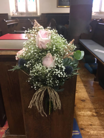 rustic looking pew ends tied in string  pink roses blue thistle