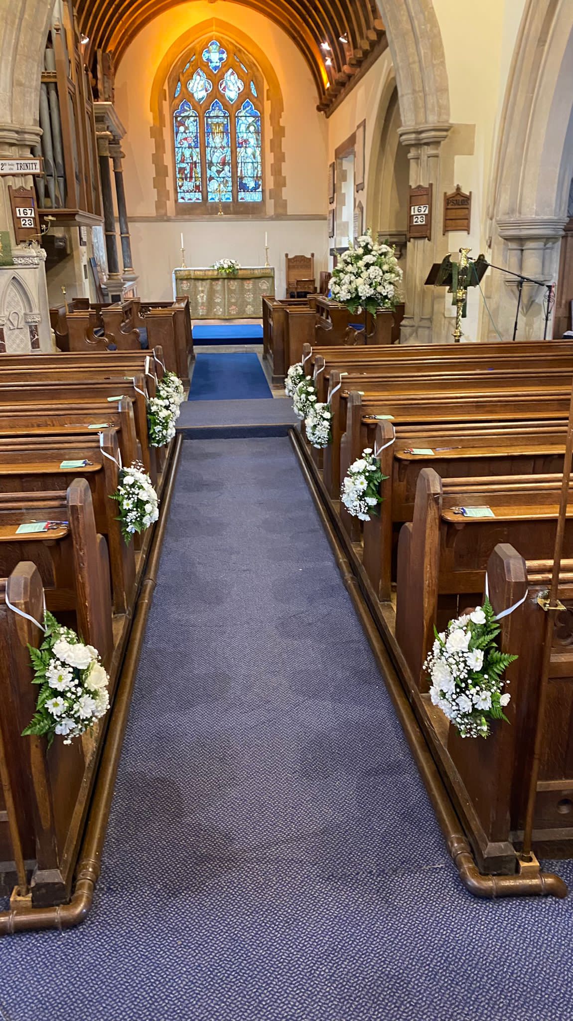 Church flowers in white , pew ends with  Pedestals