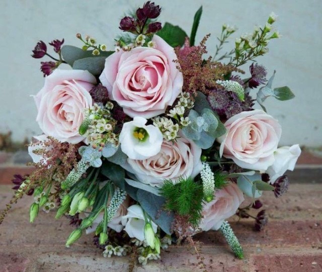 rustic wild theme wedding bouquet of roses lisianthus and freesia veronnica and wax flower and foliages
