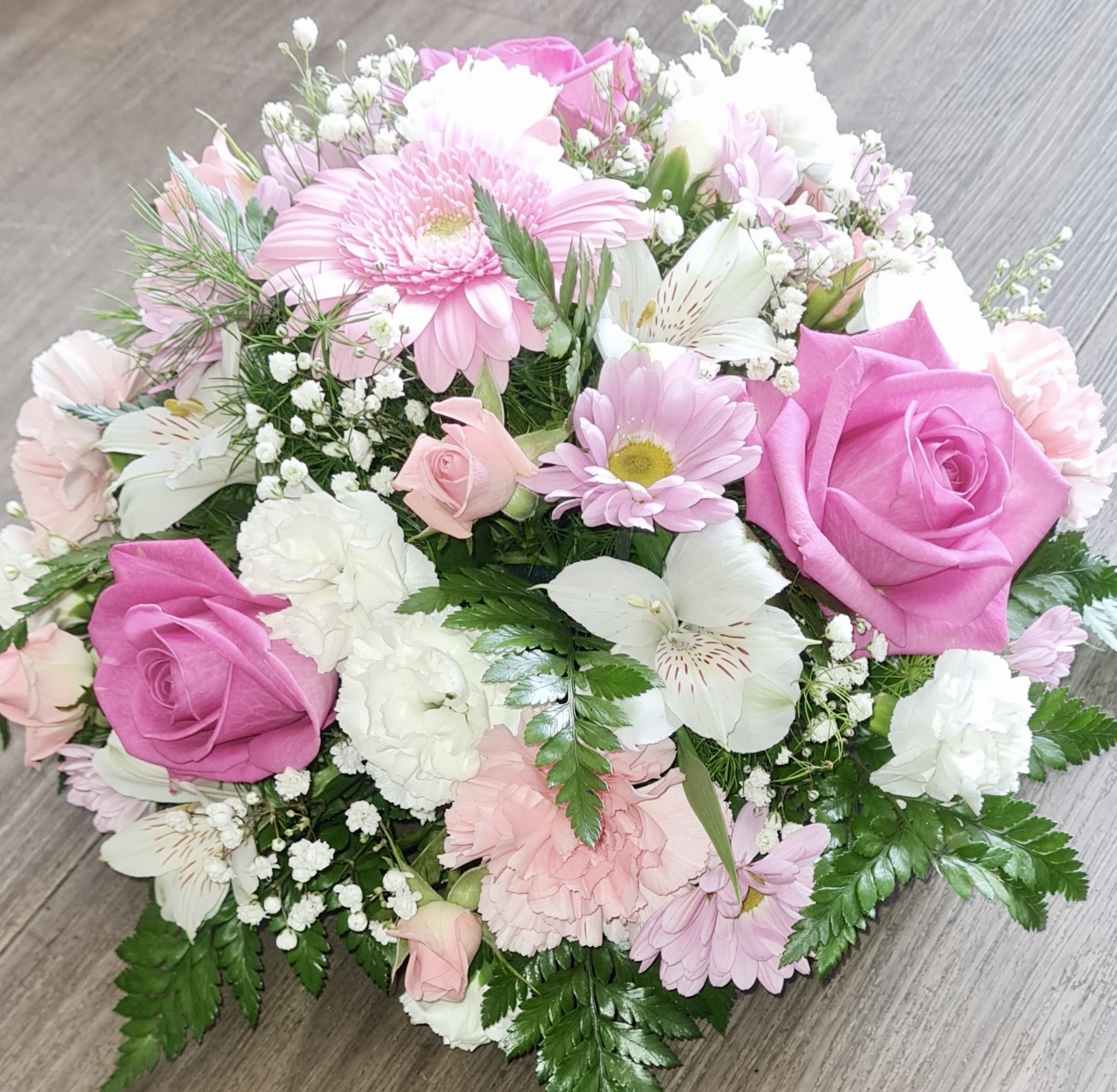 A tranquil and peaceful posy tribute. A selection of pink and white pretty flowers and subtle foliage. Available in other colours. Same day delivery. Due to seasonal variations some items may be substituted to produce a display of equal quality and value. Professionally arranged by our expert florists with care. Delivered by hand by our own driver. Click & collect is also available