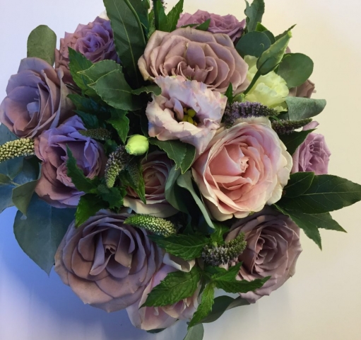 wedding flowers for bride in a hand tied style just roses lisianthus mint and bay leaves