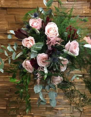 hand tied of roses thistle and lisianthus  freesia and veronica wild style