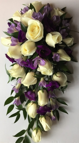bridal flowers in a shower bouquet loose style of mint veronica and foliage lilac roses with ivory roses and purple lisianthus  cascading wedding bouquet florist in studley flair with flowers