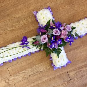 A traditional massed cross with a spray in the centre. this item can be ribbon or foliage edged with colours of your choice. 24 hours notice required. Due to seasonal variations some items may be substituted to produce a display of equal quality and value. Professionally arranged by our expert florists with care. Delivered by hand by our own driver. Click & collect is also available