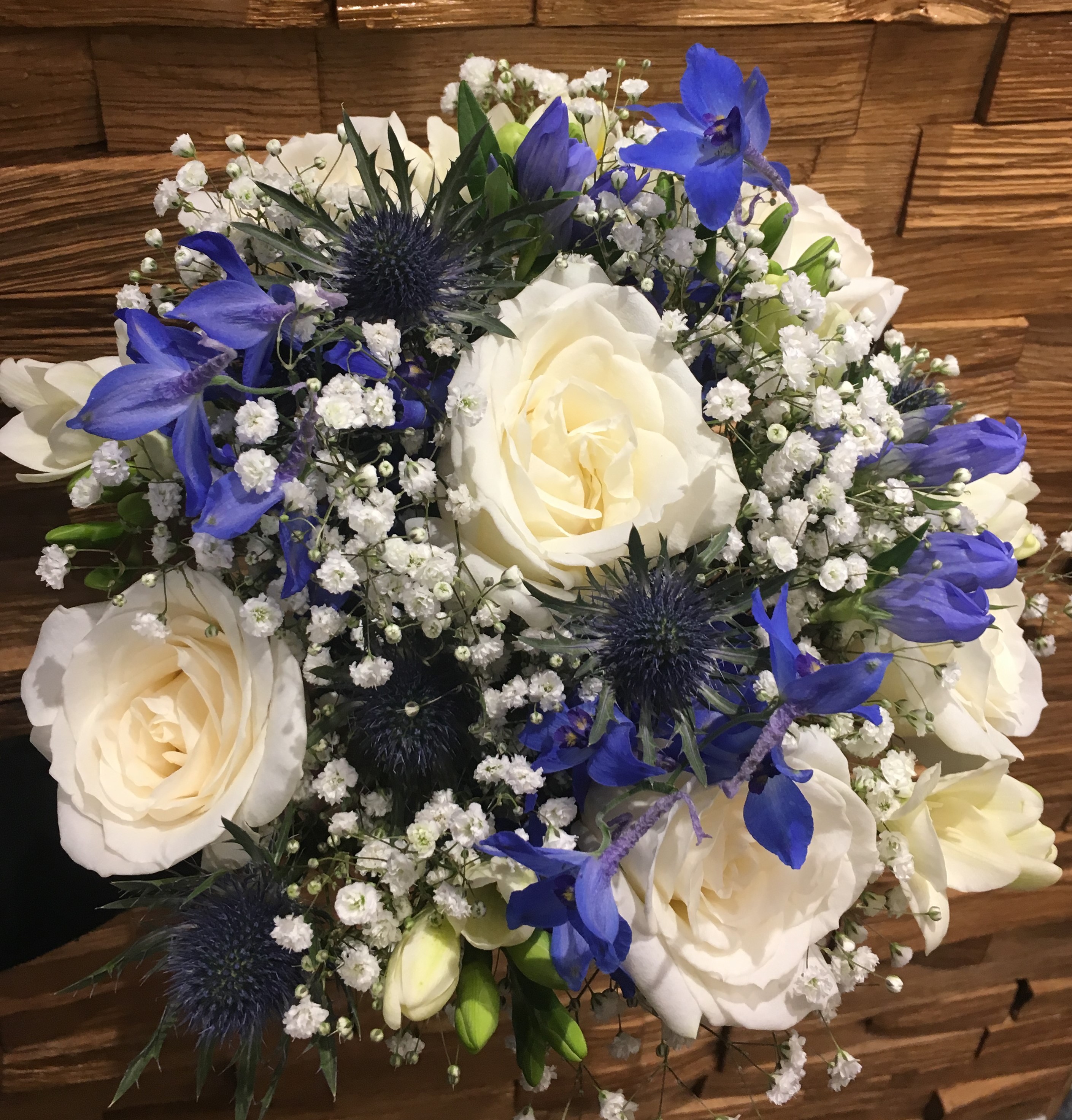 blue thistle ivory roses with blue delphiniums freesia scented bouquet