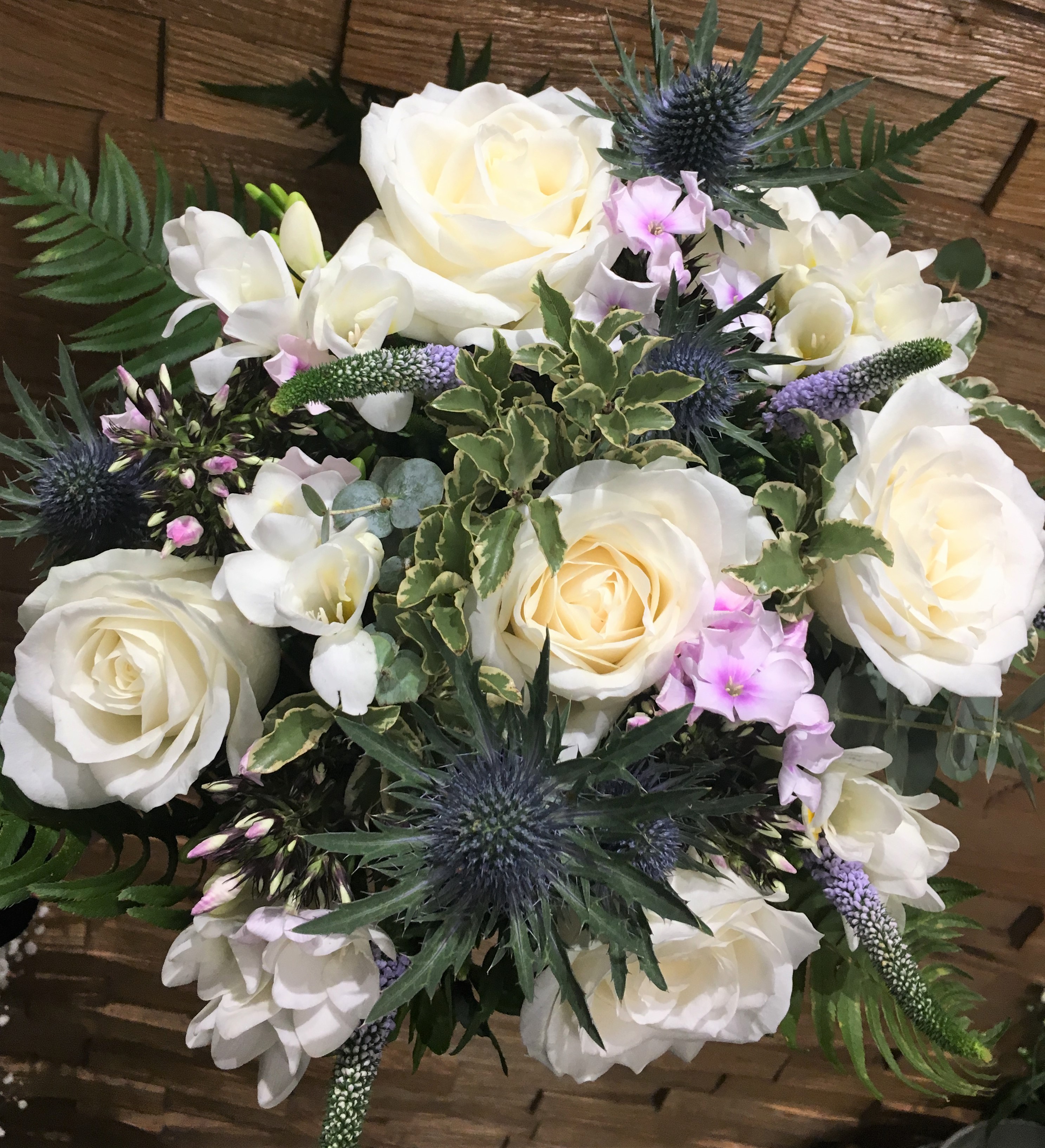 hand tied of roses thistle and lisianthus  freesia and veronica