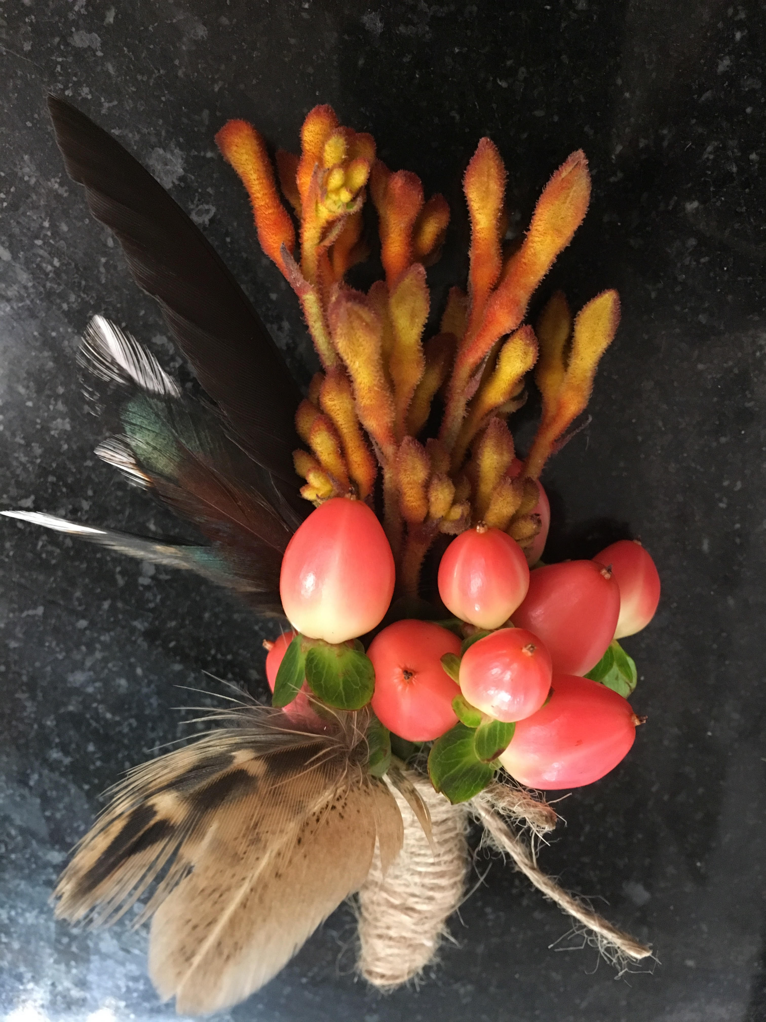 Pheasant feather with orange flower buttonhole