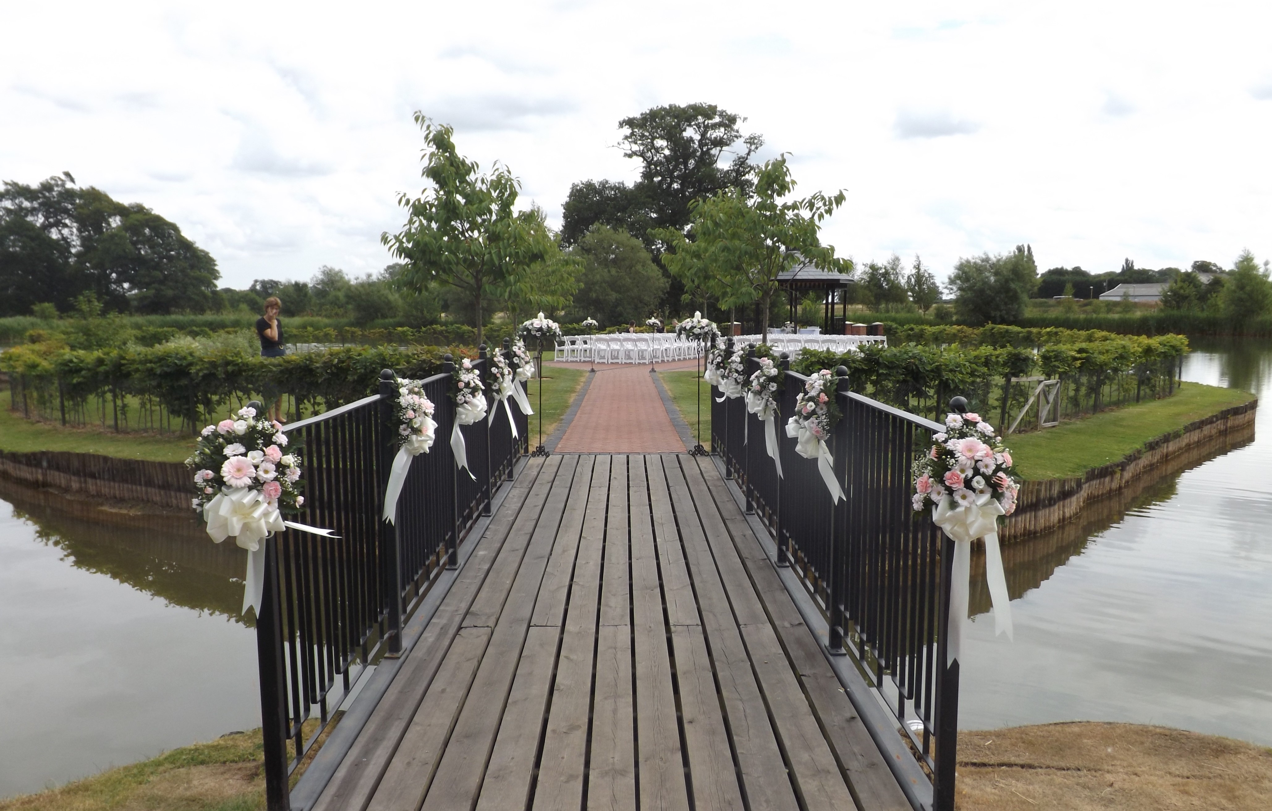 pink & white pew end & bows over bridge ardencote manor