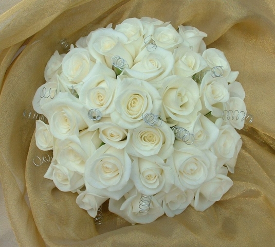 wedding flowers for bride in a hand tied style just ivory  roses
