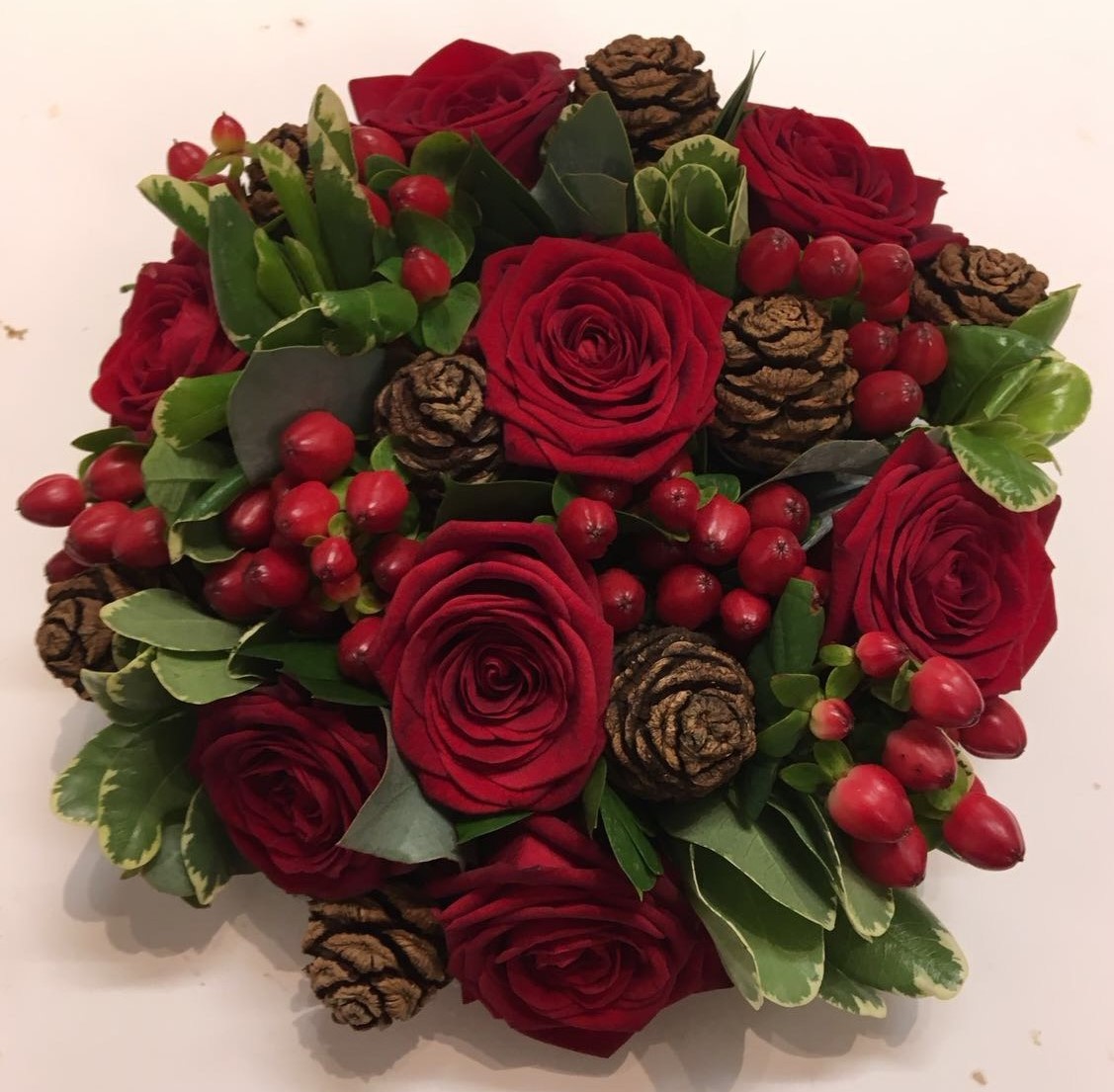 bridal flowers in a hand tied red roses hyperican cones