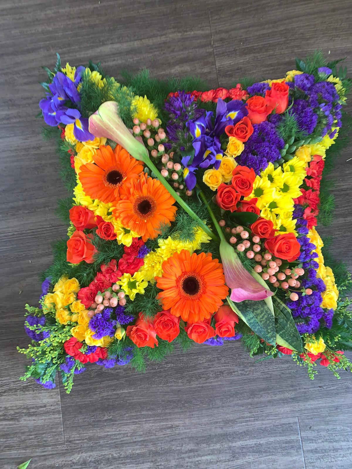 vibrant cushion funeral flowers