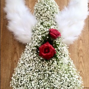 A lovely massed angel in white with touches of feathers and glitter on the flowers Colour of you choice 24hrs notice required Due to seasonal variations some items may be substituted to produce a display of equal quality and value. Professionally arranged by our expert florists with care. Delivered by hand by our own driver. Click & collect is also available