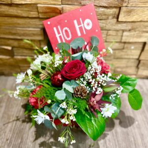 This traditional arrangement of seasonal flowers & Christmas foliages will make a beautiful addition to your home this christmas