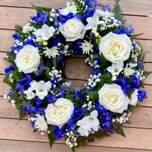 This beautiful blue and white wreath, symbolising peace and serenity. This elegant arrangement combines lush blue blooms with pure white flowers, offering a heartfelt tribute of respect and remembrance. Perfect for expressing condolences and bringing comfort during a time of loss. Each wreath is carefully crafted to ensure it reflects both beauty and grace during this difficult time.